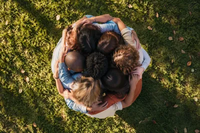 Overhead Friends Group Hug on Sunlit Lawn