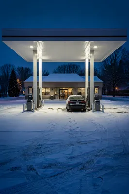 Evening Car Fueling at Snowy Gas Station