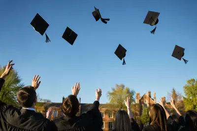 Graduation Caps Flying Over Campus Lawn