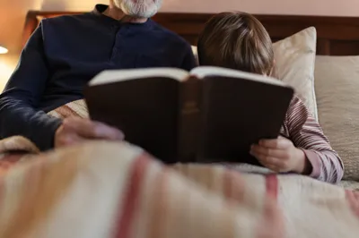 Grandfather and Grandchild Reading Bible at Bedtime