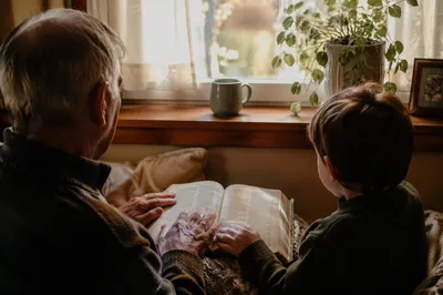 Grandfather and Grandchild Reading Bible Together