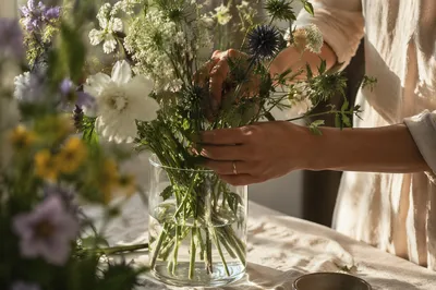 Hands Arranging Garden Bouquet in Glass Vase