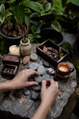 Hands Arranging Stones on Garden Altar
