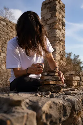 Hands Building a Stone Altar Outdoors