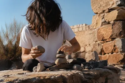 Hands Building a Stone Altar Outdoors