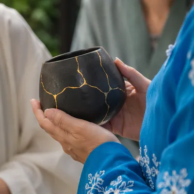 Hands Holding Gold Repaired Kintsugi Pottery