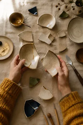 Hands Holding Broken Pottery for Kintsugi Repair