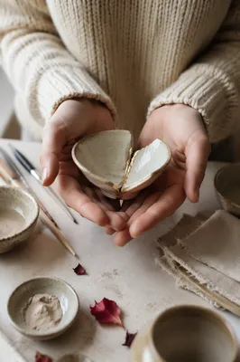 Hands Holding Kintsugi Repaired Broken Pottery
