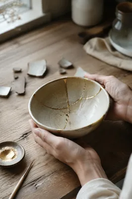 Hands Holding Gold Repaired Kintsugi Bowl