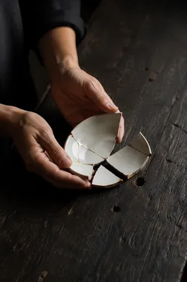 Hands Holding Broken Pottery with Kintsugi