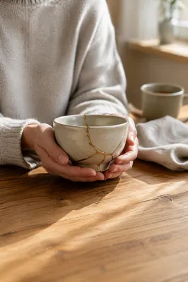 Hands Holding Kintsugi Bowl in Morning Light
