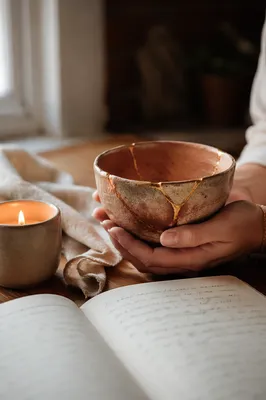 Hands Holding Kintsugi Bowl in Morning Light
