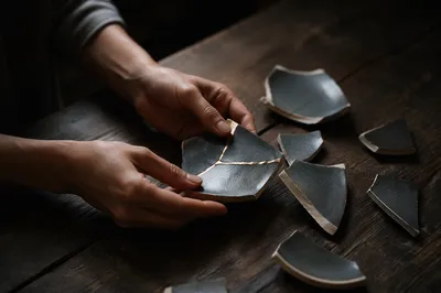 Hands Arranging Kintsugi Pottery Shards