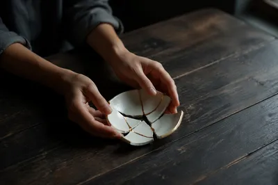 Hands Holding Broken Pottery with Kintsugi