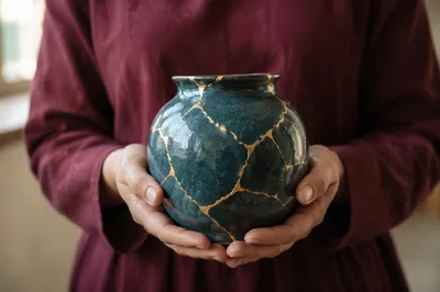 Hands Holding Kintsugi Pottery of Hope