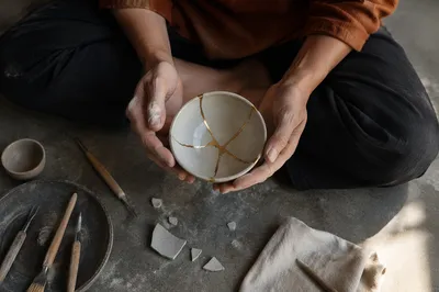 Hands Holding Restored Kintsugi Ceramic Bowl