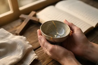Hands Holding Kintsugi Bowl in Prayer