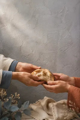 Hands Sharing Rustic Bread in Soft Light