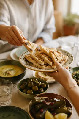 Hands Sharing Bread at Warm Communal Table