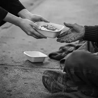 Compassionate Hands Serving Meal to Homeless Neighbor