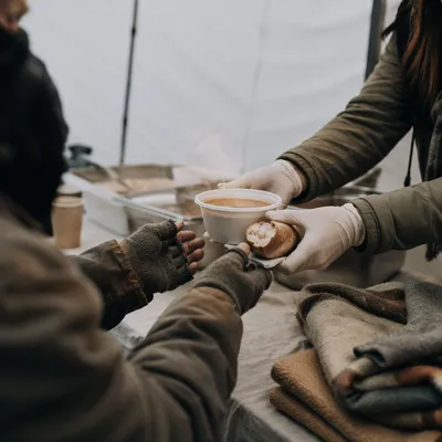 Compassionate Hands Serving Soup to Homeless