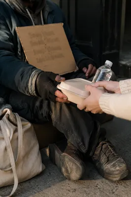 Volunteer Hands Offering Meal to Homeless
