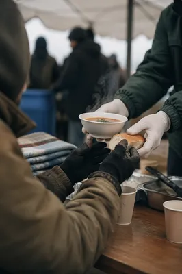 Compassionate Hands Serving Soup Outdoors