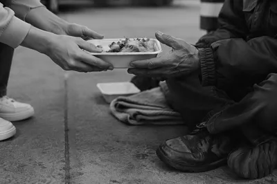 Volunteers Serving Hot Meal to Unhoused Neighbor