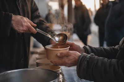 Compassionate Hands Serving Soup to Homeless