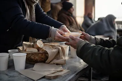 Hands Serving Warm Meals to Homeless