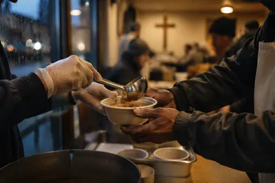 Volunteer Hands Serving Soup in Meal Hall
