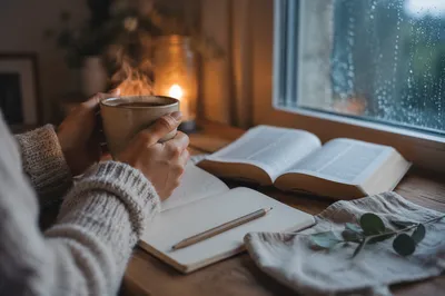 Hands Holding Coffee Beside Open Journal