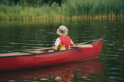 Child Camper Canoeing on Quiet Summer Lake