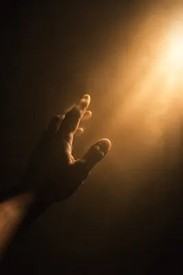 Hand Reaching Toward Hopeful Golden Light