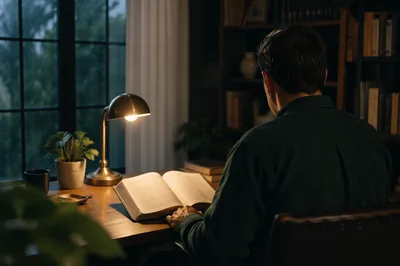 Man Reading Bible by Desk Lamp