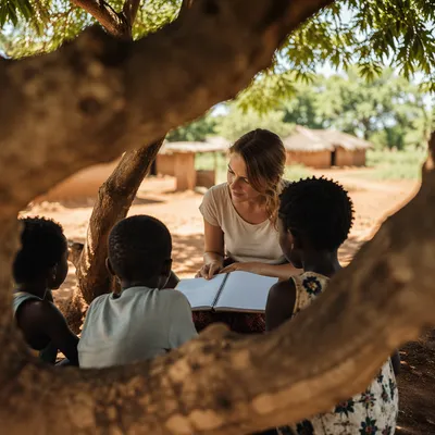 Missionary Teaching Children Beneath African Shade Tree
