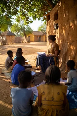 Missionary Teaching Children Beneath African Shade Tree
