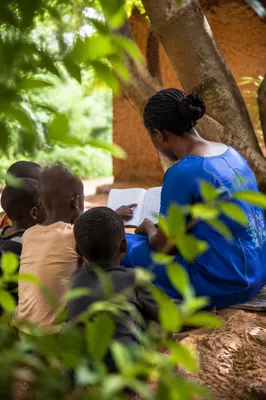 Missionary Teaching Children Beneath African Tree