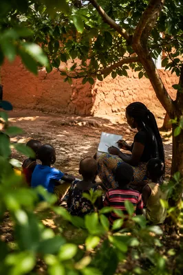 Missionary Teaching Children Beneath African Tree