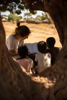 Missionary Teaching Children Beneath African Tree