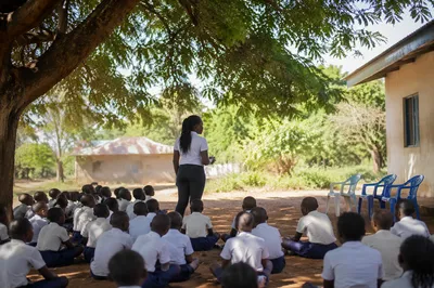 Volunteer Educator Teaching Children Under African Tree