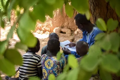 Missionary Teaching Children Beneath African Tree