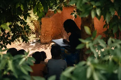 Missionary Teacher with Children Under African Tree