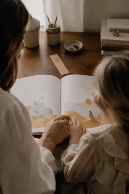 Mother and Child Reading at Wooden Desk