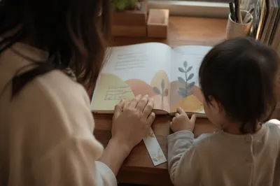 Mother and Child Reading at Wooden Desk