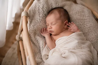 Newborn Baby Sleeping in Wooden Bassinet