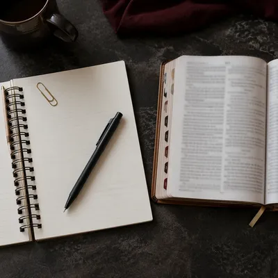 Open Notebook Beside Scripture Study Pages