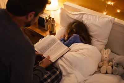 Parent Reading Bible at Child Bedtime