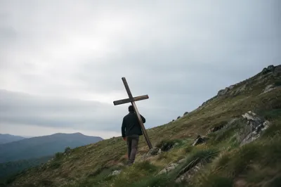 Lone Believer Carrying Cross Uphill