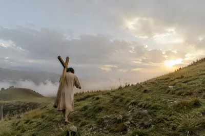 Person Carrying Cross Up Misty Hillside